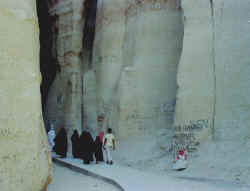 Visitors follow a paved walkway into Al Qara Cave]